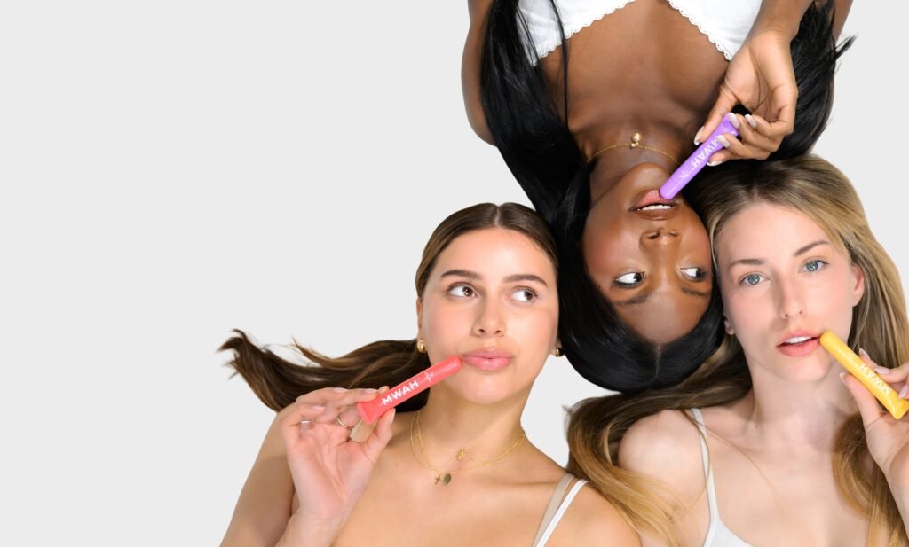MWAH lip gloss pen in four flavours, held by four women